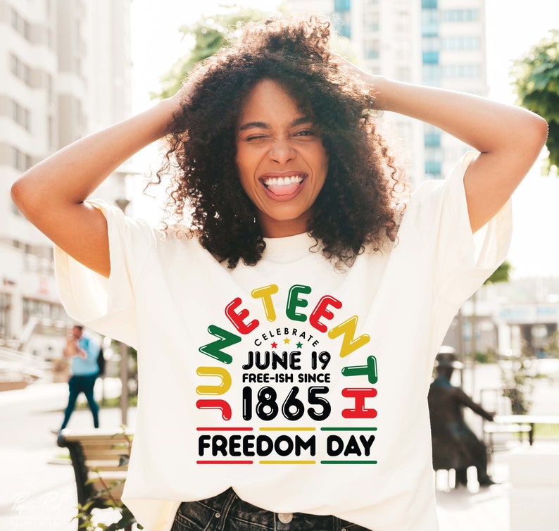 May include: A white t-shirt with a colorful graphic design that says "Juneteenth Celebrate June 19 Free-ish Since 1865 Freedom Day".