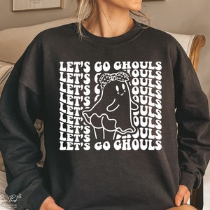 May include: Black sweatshirt with a white graphic of a ghost wearing a bandana and the text "Let's Go Ghouls" repeated in a retro font.