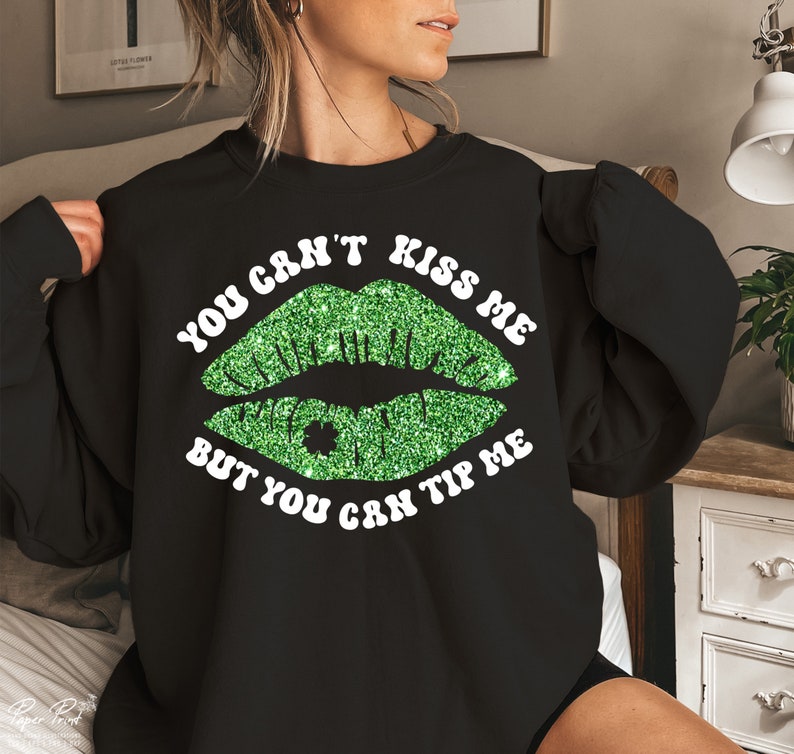 May include: Black sweatshirt with a green glitter lip print and the text "You can't kiss me but you can tip me".