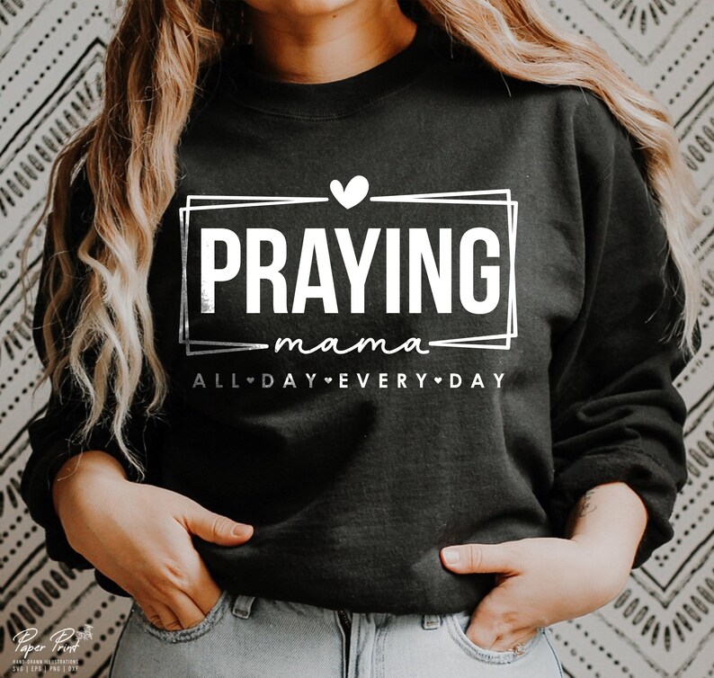 May include: Black sweatshirt with white text that reads "Praying mama all day every day" with a heart symbol between each word.