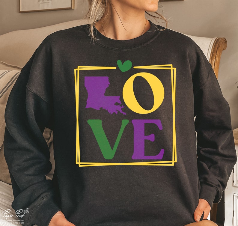 May include: Black sweatshirt with a graphic print of the word "LOVE" in purple, green, and yellow. The letter "O" is replaced with the outline of the state of Louisiana. A small green heart is above the graphic.