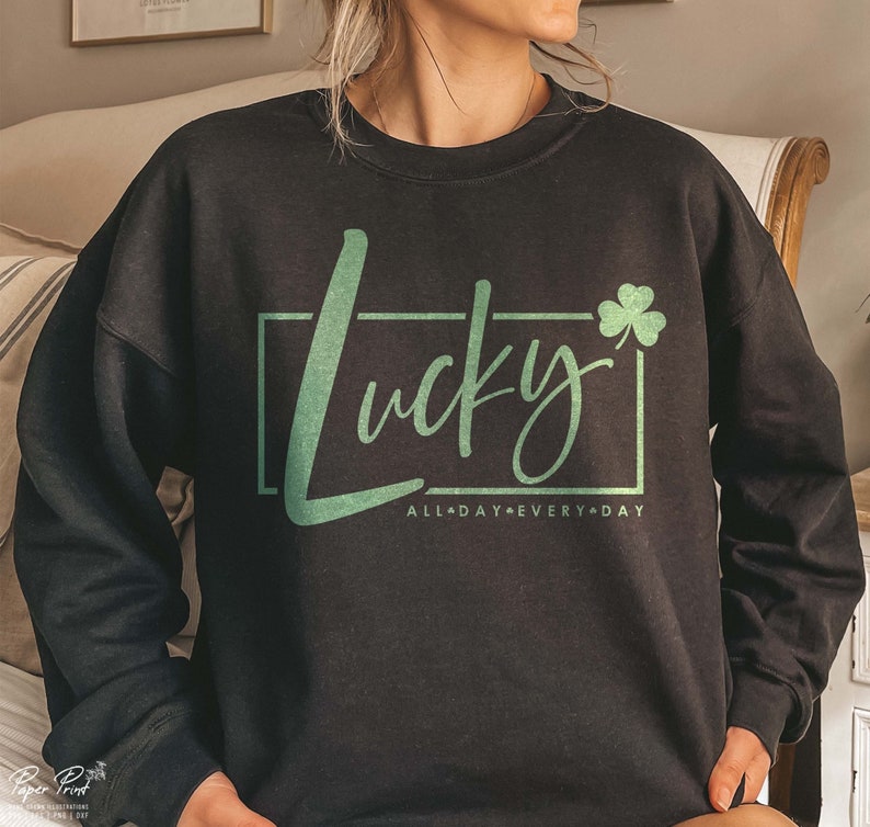 May include: Black sweatshirt with a green shamrock and the text "Lucky All Day Every Day" in a white box.