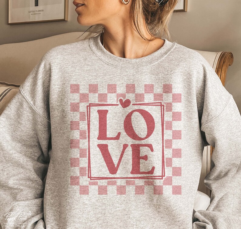 May include: A grey sweatshirt with a pink and white checkered pattern and the word "LOVE" in a pink box.