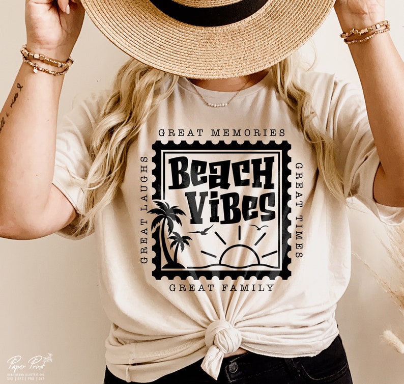 Puede incluir: Una camiseta blanca con un gr&aacute;fico negro de un sello con el texto "Beach Vibes" en su interior. El sello tiene el texto "Great Memories", "Great Times", "Great Laughs" y "Great Family" alrededor.