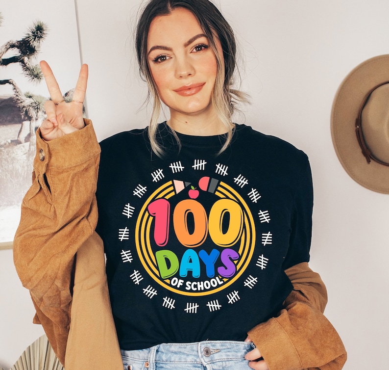 May include: Black t-shirt with a rainbow colored circle graphic that says "100 Days of School" with a red apple and pencil inside the circle. The circle is surrounded by white tally marks.
