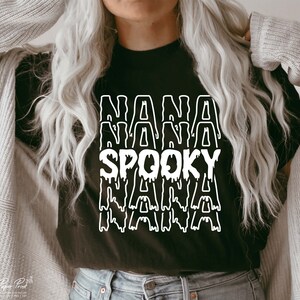 May include: Black t-shirt with a white graphic that says "NANA SPOOKY NANA" in a dripping font.