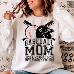 以下が含まれることがあります： 黒と赤の野球のグラフィックと「Baseball Mom Like a Normal Mom But Louder & Prouder」というテキストが書かれた白いスウェットシャツ。