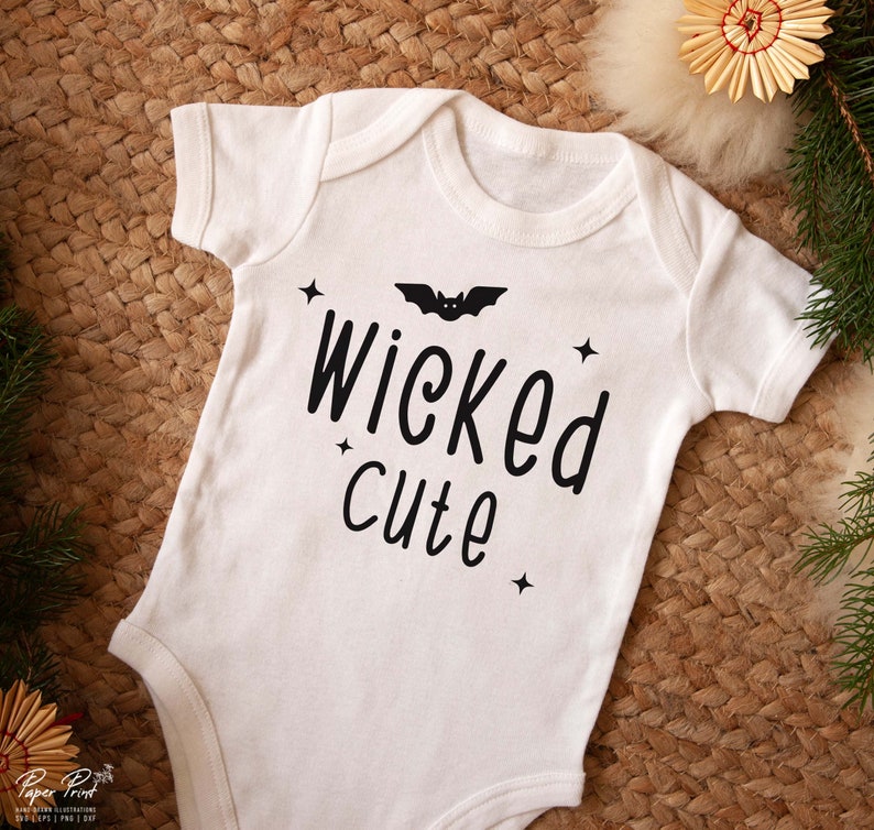 May include: White baby onesie with black text that reads "Wicked cute" and a black bat graphic.