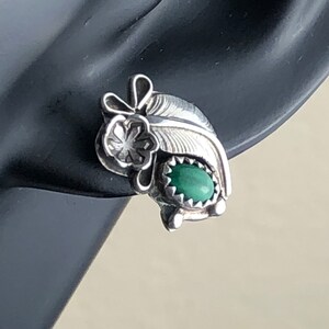 May include: Sterling silver earrings featuring a green stone and a feather design.