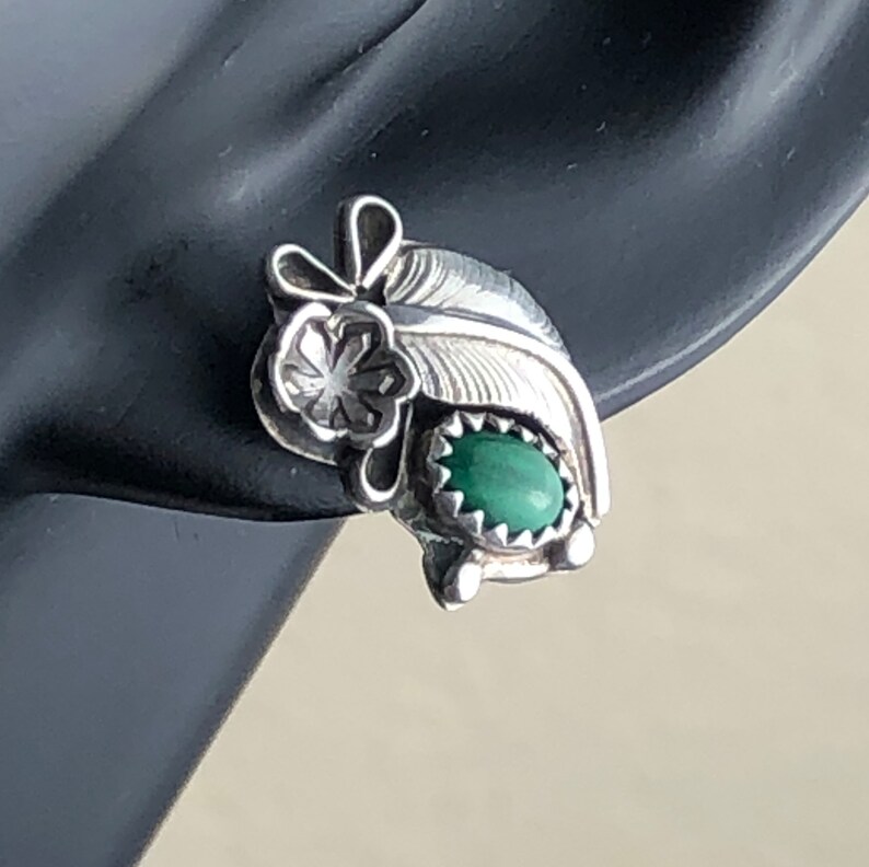 May include: Sterling silver earrings featuring a green stone and a feather design.