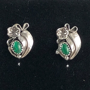 May include: A pair of silver earrings with green malachite stones. The earrings feature a floral design with a feather motif.