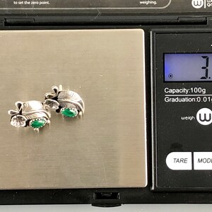 May include: A pair of silver earrings with green stones, weighing 3.31 grams on a digital scale. The scale reads "TOP-100" and has a capacity of 100 grams with a graduation of 0.01 grams.