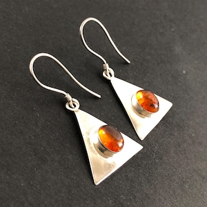 Modernistiska örhängen i sterlingsilver och konjaksbärnsten med cabochon, triangelformade, hålade trådar