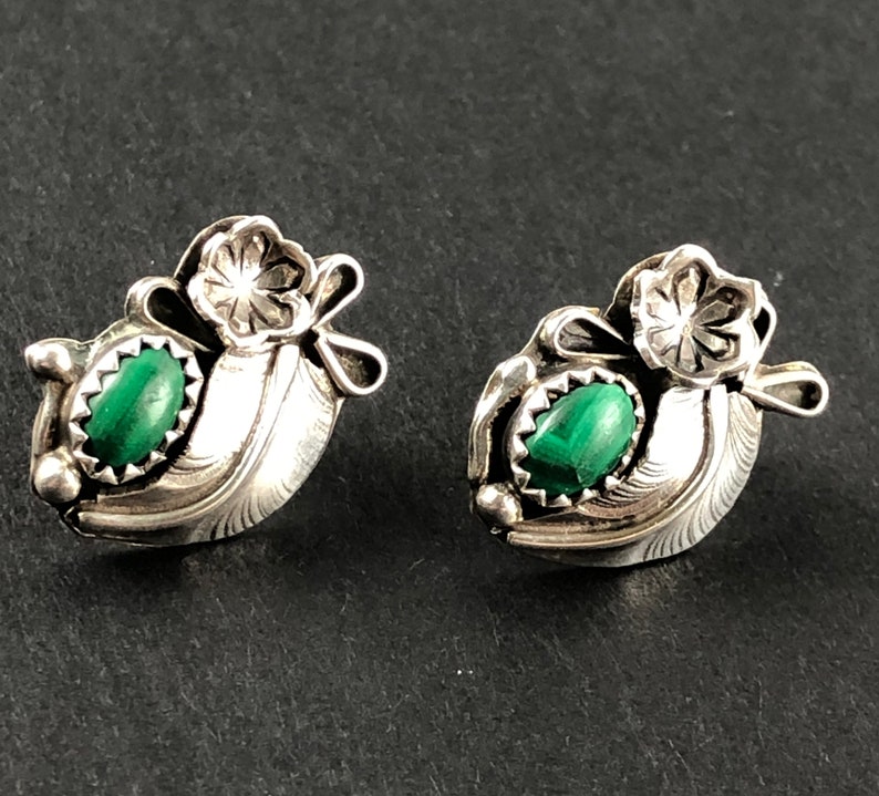 May include: A pair of silver earrings featuring green malachite stones and a floral design.