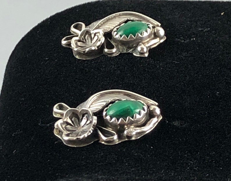 May include: A pair of sterling silver earrings featuring green malachite stones and floral designs.