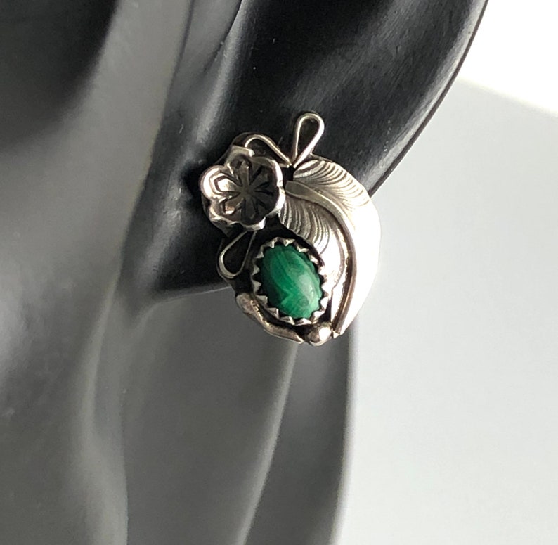 May include: Sterling silver earrings featuring a green malachite stone and a floral design.