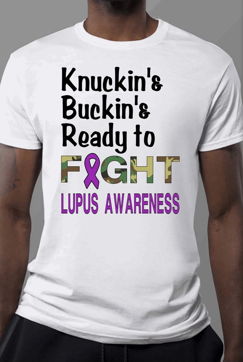 May include: White t-shirt with a purple ribbon and the text "Knuckin's Buckin's Ready to FIGHT LUPUS AWARENESS" in black and green camouflage print.