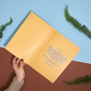 May include: A yellow card with a handwritten message that reads "Charlie, Two years together! I'm so proud of us and the life and family we're building together. Time is flying by and I'm enjoying every second of it. Here's to the rest of our lives together. Charlotte X."