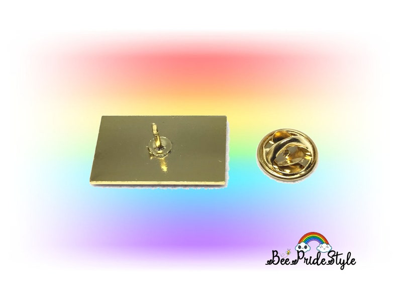 May include: A gold-colored rectangular pin with a pin back and a separate clasp. The pin has a rainbow-colored border. The text "Bee Pride Style" is visible in the lower right corner.
