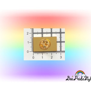 May include: A gold-colored rectangular pin with a butterfly design, measuring approximately 1 inch in length. The pin is set against a white grid background with rainbow gradient colors. The text "Bee Pride Style" is in the bottom right corner.
