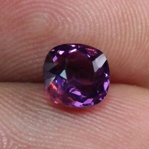 Pu&ograve; includere: Una pietra preziosa di colore viola scuro con taglio a cuscino. La pietra preziosa &egrave; sfaccettata e ha un'alta lucidatura.