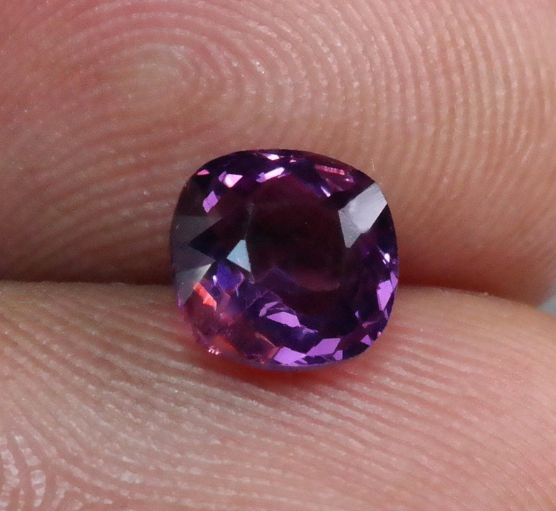 Pu&ograve; includere: Una pietra preziosa di colore viola scuro con taglio a cuscino. La pietra preziosa &egrave; sfaccettata e ha un'alta lucidatura.