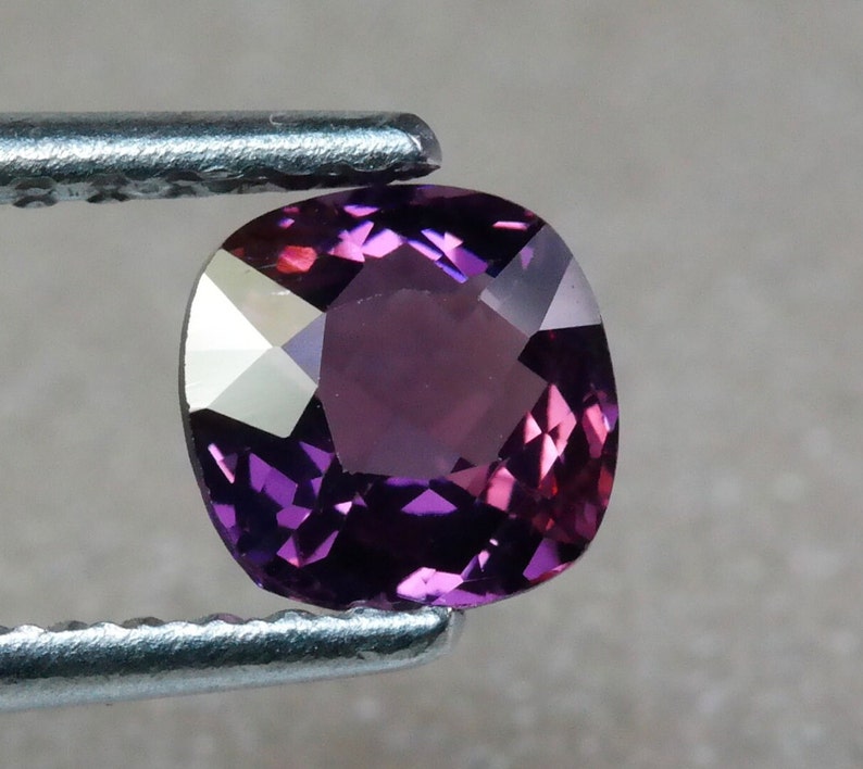 Pu&ograve; includere: Una pietra preziosa viola a taglio cuscino con una superficie sfaccettata.