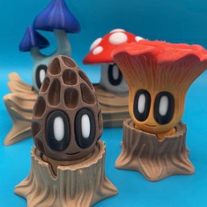 May include: A collection of whimsical mushroom figurines in various colors, including blue, red, and brown. Each mushroom has a unique design and is set on a tree stump base. The figurines have cartoon-like faces with large eyes.
