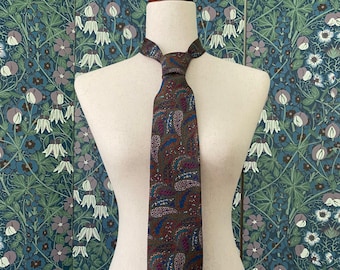 Könnte beinhalten: Eine braune Seidenkrawatte mit Paisley-Muster in Blau, Rot und Grün.