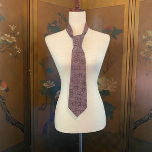 Vintage silk necktie by Halston in faded pink with graphic prints