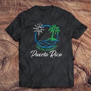May include: Black t-shirt with a blue, green, and white graphic design of a sun, palm tree, and waves. The text "Isla del Encanto Puerto Rico" is written below the graphic.