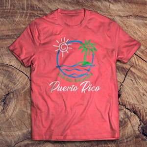 May include: A red t-shirt with a white graphic design of a sun, palm tree, and waves in a circle. The text "Isla del Encanto Puerto Rico" is written below the graphic.