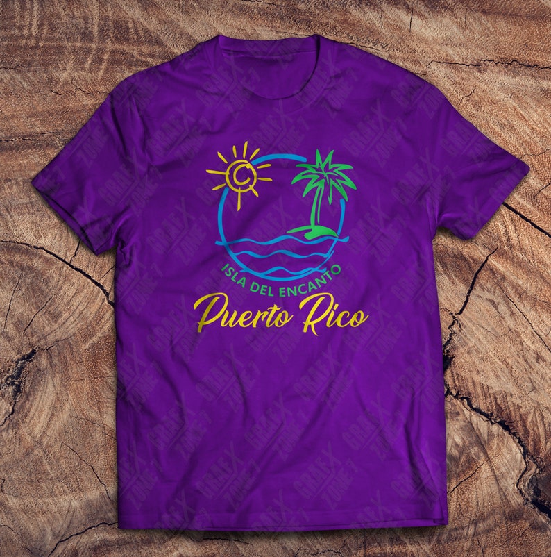 May include: Purple t-shirt with a graphic design of a sun, palm tree, and waves. The text "Isla del Encanto Puerto Rico" is written in yellow below the graphic.
