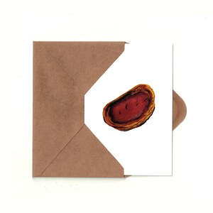 May include: A greeting card featuring a colorful illustration of a pastry, with a brown envelope. The pastry is a reddish-brown color with a yellow-brown crust. The card is on a white background.
