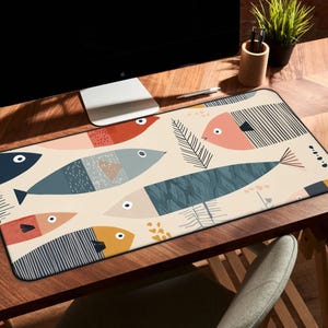 May include: A rectangular desk mat featuring a cream-colored background with a repeating pattern of stylized fish in shades of blue, orange, yellow, and dark gray, interspersed with thin, dark line-drawn fern-like botanical elements.