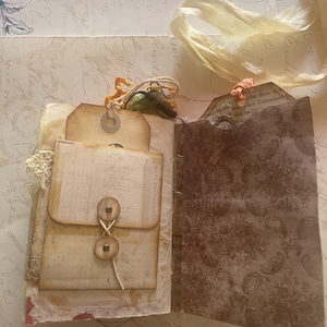 May include: A white ceramic mug with a black handle and the text "But First, Coffee" in a bold, black font. The mug is set against a neutral background, highlighting its simple design.