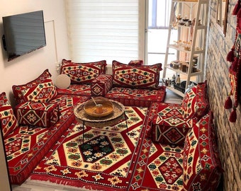 Conjunto de sofás vermelhos orientais com assentos no chão: almofadas e tapetes turcos Majlis