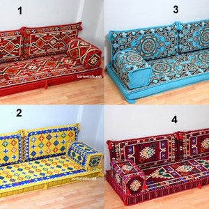 May include: Four different styles of floor cushions, each with a different color and pattern. The cushions are made of fabric and have a traditional design. The cushions are arranged in a grid pattern, with each cushion labeled with a number from 1 to 4.
