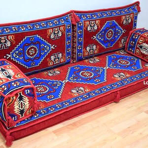 Puede incluir: Un coj&iacute;n de suelo rojo y azul con un coj&iacute;n de respaldo a juego y dos cojines m&aacute;s peque&ntilde;os. Los cojines est&aacute;n hechos de una tela suave y mullida y tienen un dise&ntilde;o tradicional. Los cojines son perfectos para descansar y relajarse.