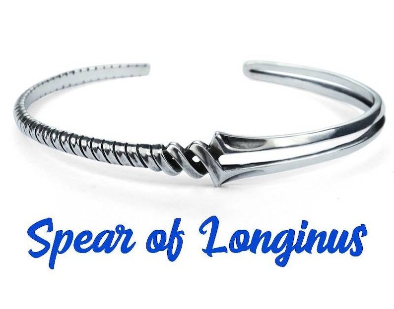 Może przedstawiać: Srebrna bransoletka z wzorem splecionej liny i zapięciem w kształcie grotu wł&oacute;czni. Bransoletka jest wygrawerowana słowami "Spear of Longinus".