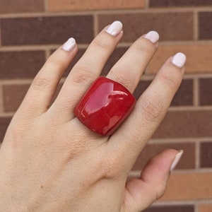 May include: A large, red, rectangular ring with a glossy finish.