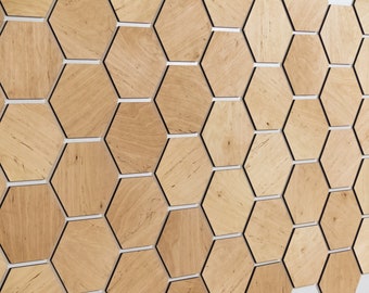May include: A wall covered in a honeycomb pattern of wooden hexagonal tiles. The tiles are a light brown color with a natural wood grain. The edges of the tiles are outlined in black.