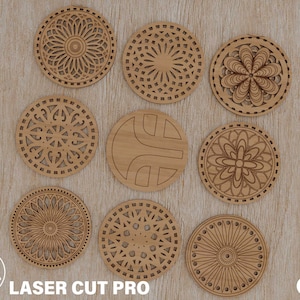 May include: Ten laser-cut wooden coasters with intricate geometric designs. The coasters are circular and feature various patterns, including floral, geometric, and abstract designs.