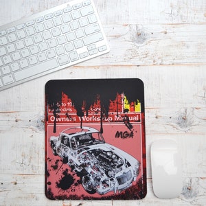 May include: A black and red mousepad with a vintage car illustration and the text "Owner's Works up Manual" and "MGA".