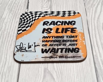 May include: A square, orange and black coaster with a checkered flag design. The coaster has a quote that reads "Racing is life. Anything that happens before or after is just waiting." The quote is attributed to Steve McQueen.