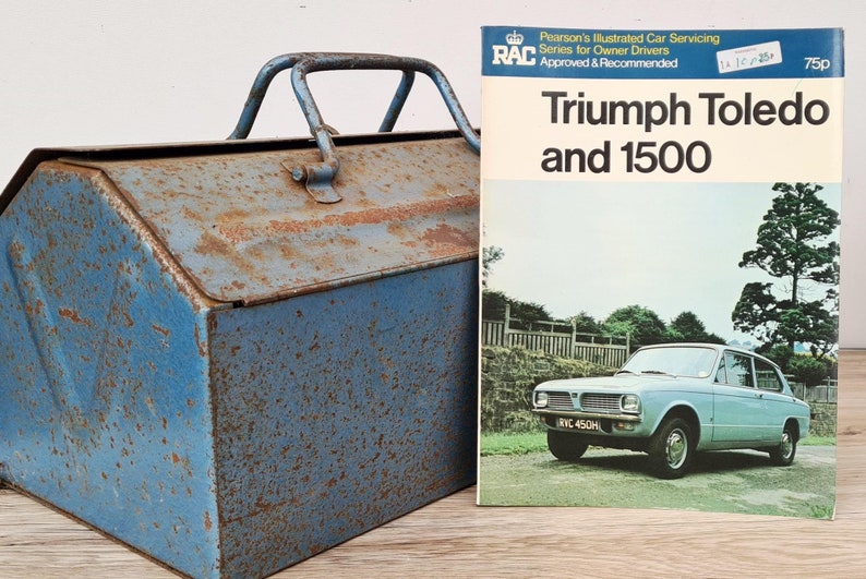 May include: A blue metal toolbox with a rusty patina and a vintage RAC Triumph Toledo and 1500 car repair manual. The manual is from Pearson's Illustrated Car Servicing series for owner drivers.