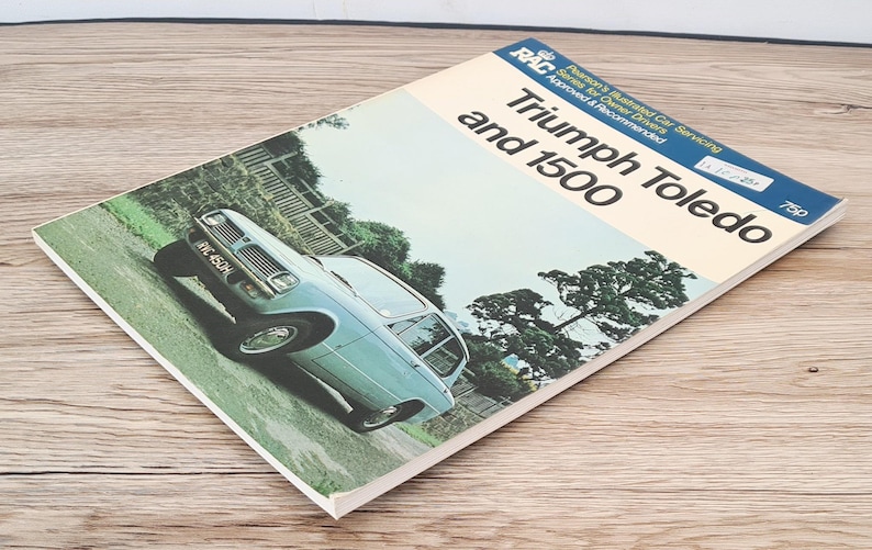 May include: A blue Triumph Toledo 1500 car driving on a road with trees on either side. The car has a white license plate that reads "HMC 450H". The image is from a vintage RAC (Royal Automobile Club) service manual.