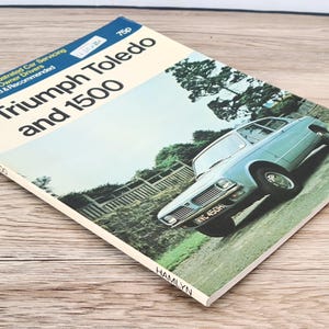 May include: A vintage RAC (Royal Automobile Club) repair manual for the Triumph Toledo and 1500 cars. The cover features a blue car with a white license plate that reads "RVC 450H".