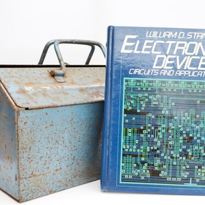 May include: A blue metal toolbox with a handle and a book titled "Electronic Devices: Circuits and Applications" by William D. Stanley.