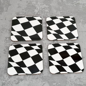 May include: Set of four black and white checkered coasters with a wavy design. The coasters are made of a durable material and are perfect for protecting your furniture from spills and scratches.